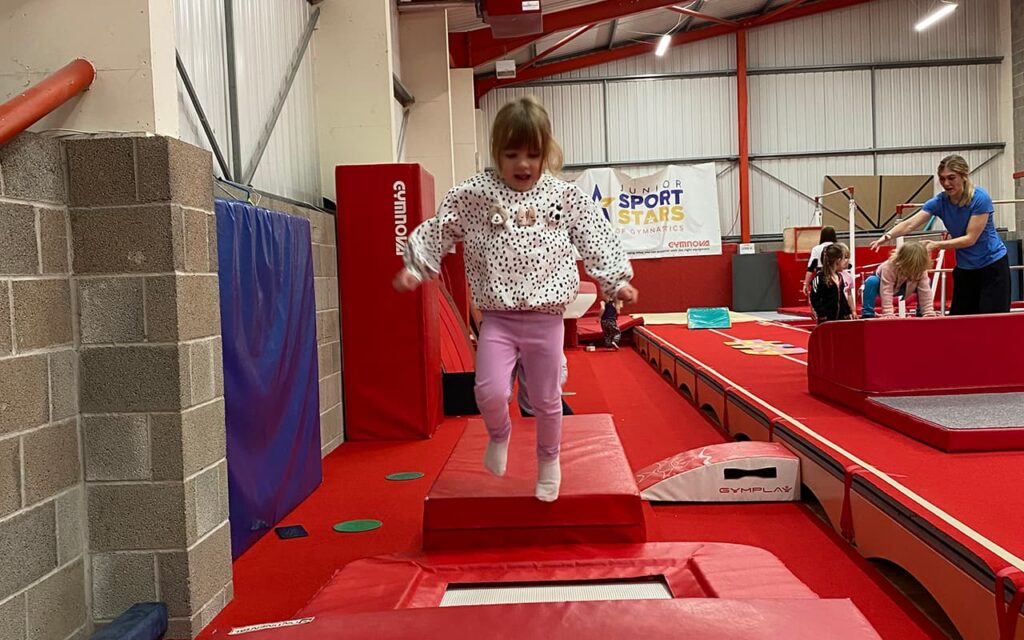 Toddler jumping in pre-school gymnastics class