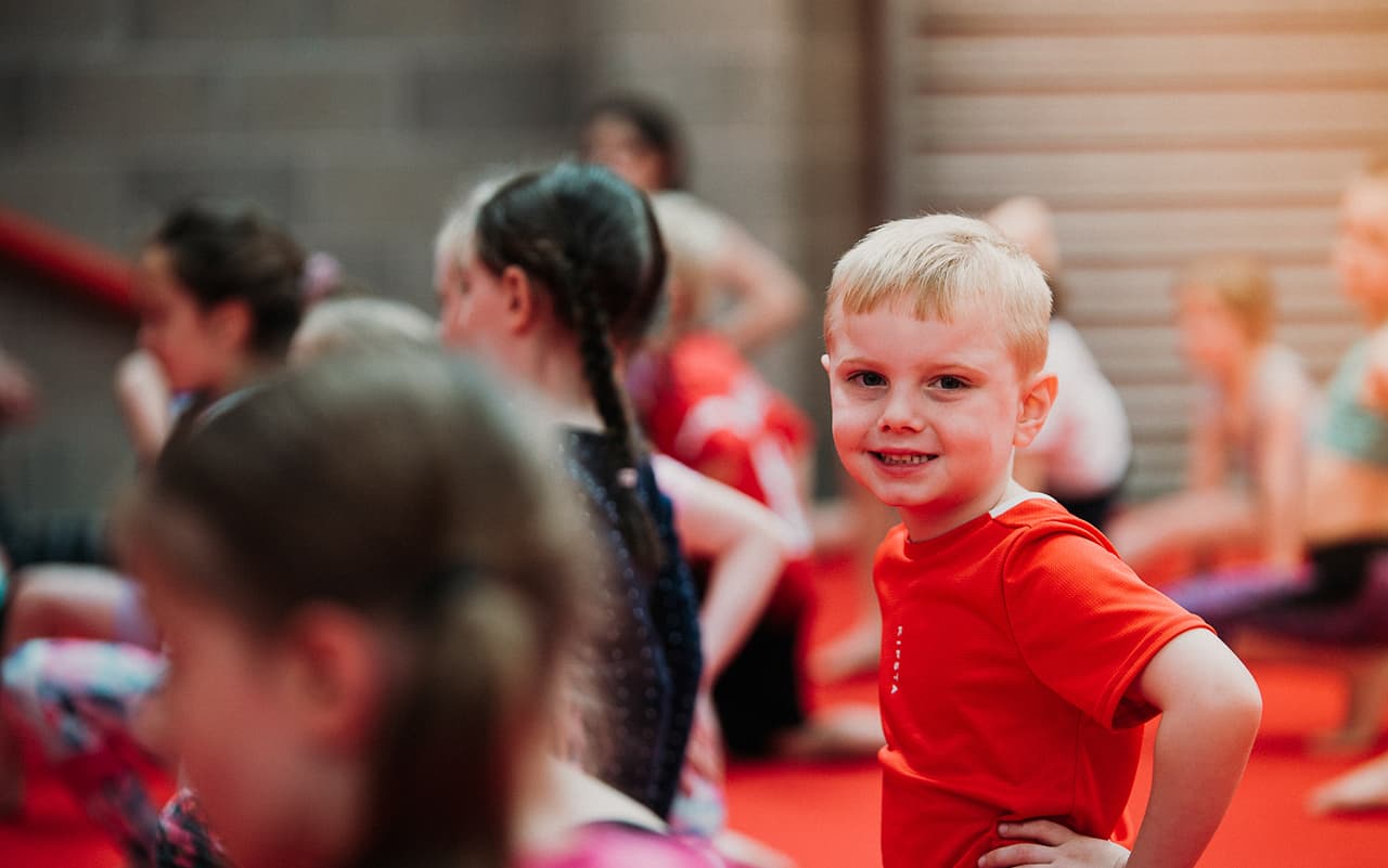 A boy smiling during children's gymnastics class