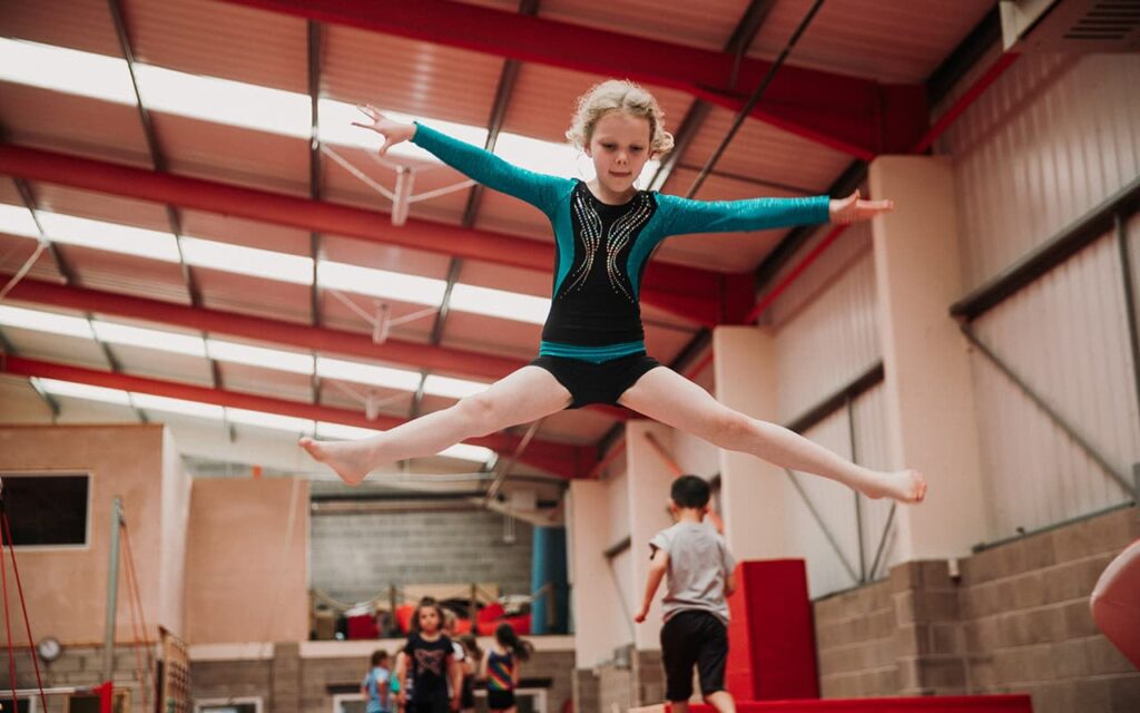 A girl star jumping during children's gymnastics class