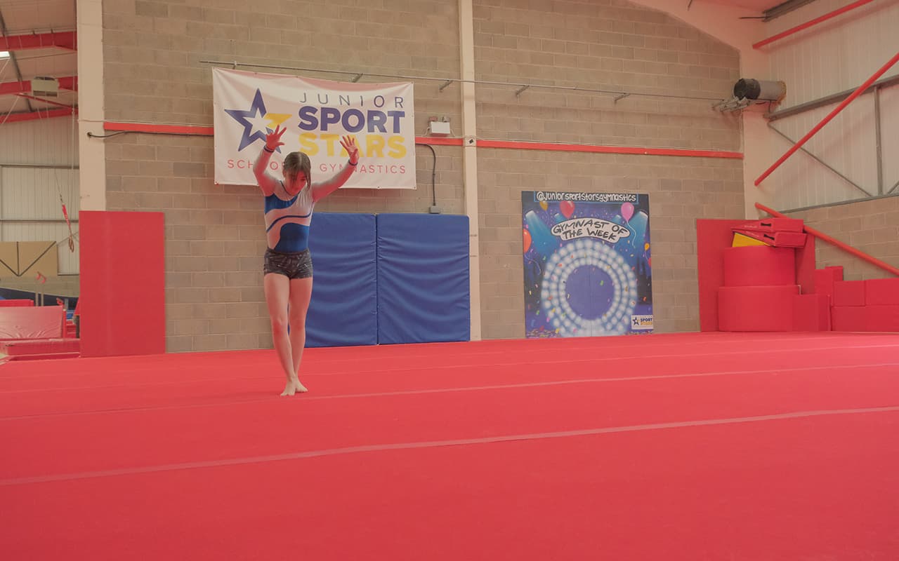 Girl training on floor for gymnastics four piece squad team